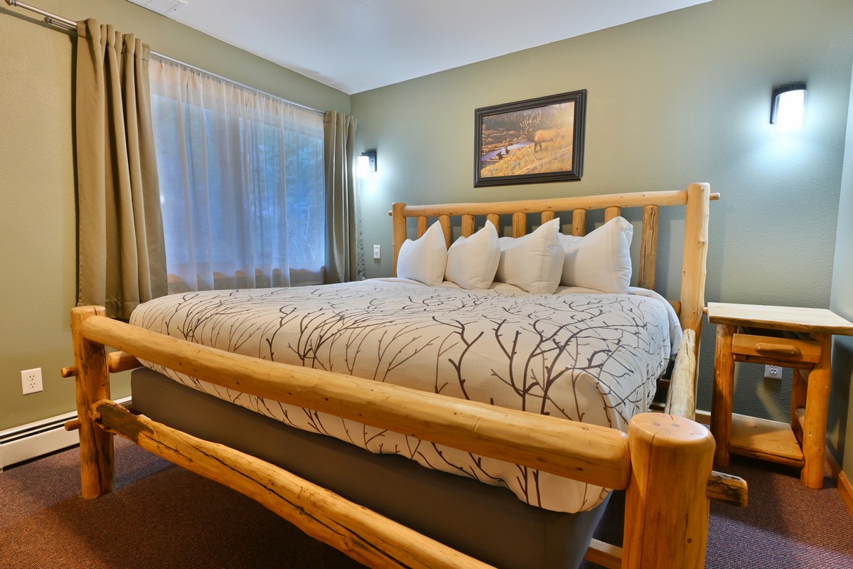 Luxurious king bed in the Riverview Suite master bedroom with plush linens